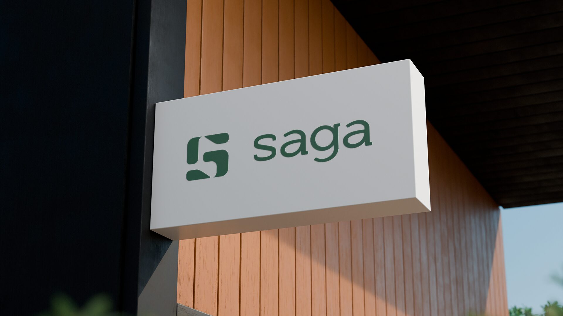 FIG.05 — a white projecting box sign carrying the Saga lockup in green, mounted on a slatted timber facade